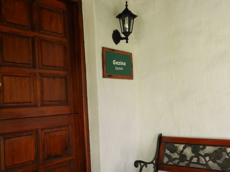 Gezina Room entrance at the President Paul Kruger Guest Lodge with wood and steel bench