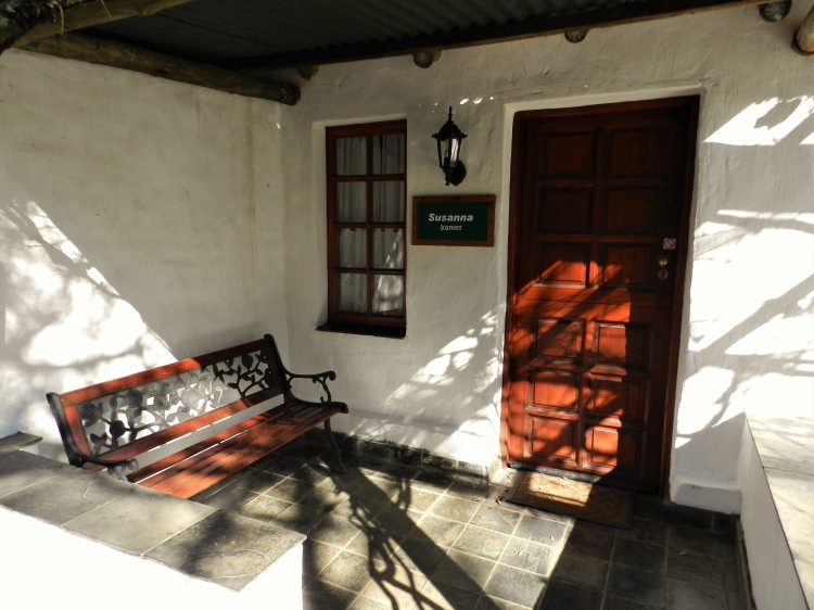 Susanna Room entrance at the President Paul Kruger Guest Lodge with wood and steel bench